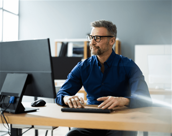 Man in blue shirt work on desktop